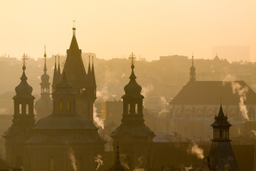 Silhouette of roofs old town of Prague in morning orange light.