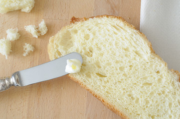 Spread the butter over a slice of bread, close up, from above