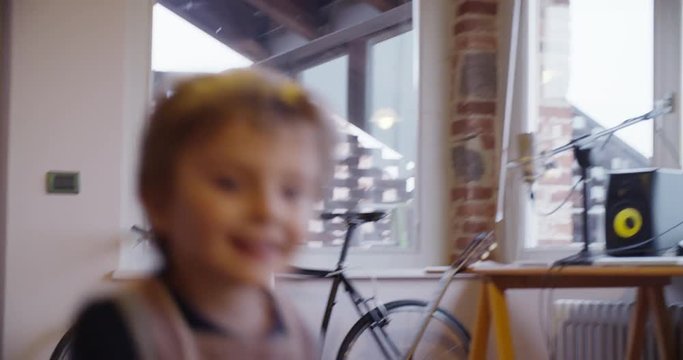 modern family little girl with dad running and playing at home. indoor in modern industrial house. caucasian. 4k handheld slow motion video shot