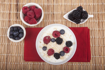 bowl of white yogurt with berries and oat flakes isolated