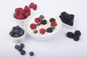 bowl of white yogurt with berries and oat flakes isolated