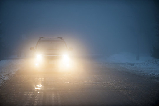 Headlights of car driving in fog