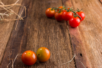 Fresh cherry tomatoes on old wooden background
