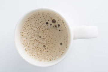 Top view of an isolated cup of Cappuccino coffee with some bubbles.