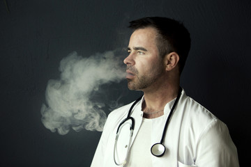 handsome doctor smoking and blowing out smoke