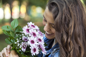 Naklejka premium Beautiful young woman holding a bouquet of flowers