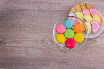 Sweet colorful macaroons on a wood background
