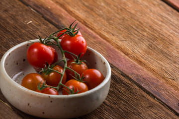 Fresh cherry tomatoes on old wooden background
