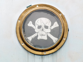 brass porthole on ship with pirate flag