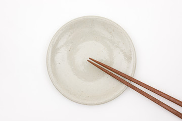 Traditional Japanese wooden chopstick on white ceramic plate