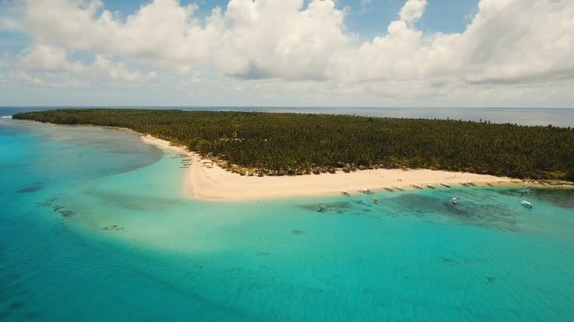 Aerial view of beautiful tropical island Daco with white sand beach. View of a nice tropical beach from the air. Beautiful sky, sea, resort. Seascape: Ocean and beautiful beach paradise. Philippines