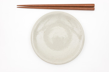 Traditional Japanese wooden chopstick and white ceramic plate