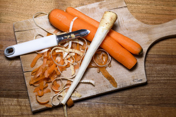 Carrots, celery, parsnips and onions on a wooden board