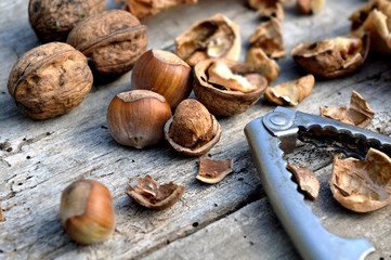 noix et noisettes décortiquées avec casse noix sur vieille planche