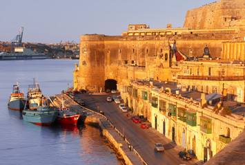 Fototapeta premium Lascaris Battery, with the Saluting Battery and the Upper Barrakka Gardens, Church of Our Lady of Liesse and Quay of Valletta at dawn, Malta.
