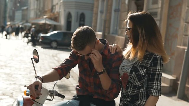 Young attractive hipster couple with retro motorbike, sunny street, urban hipster concept, 120FPS slowmotion