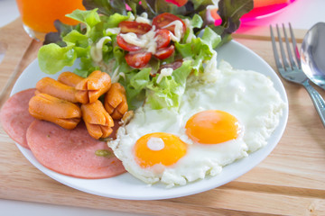  Breakfast with fried eggs, bacon, sausages, toasts and fresh salad