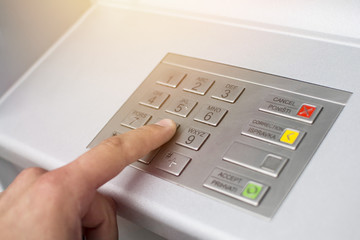 Hand of a man with a credit card, using an ATM. Man using an atm machine with his credit card. Bank...