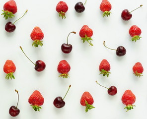 Pattern of fresh strawberries and cherries on white background. top view. flat lay