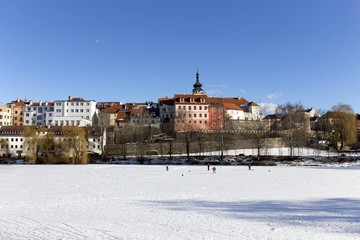 Fototapeta na wymiar Colorful royal snowy medieval Town Pisek above the frozen river Otava, Czech Republic 