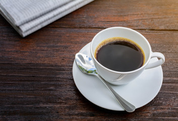 coffee cup clock and news paper on old wooden table nature background
