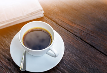 coffee cup clock and news paper on old wooden table nature background