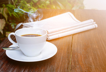coffee cup clock and news paper on old wooden table nature background