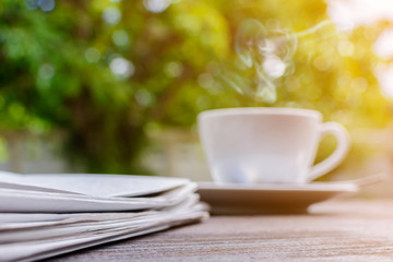 coffee cup clock and news paper on old wooden table nature background