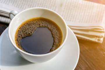 coffee cup clock and news paper on old wooden table nature background