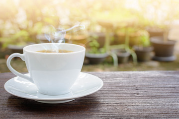 coffee cup clock and news paper on old wooden table nature background
