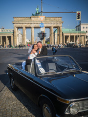 Newlywed couple sitting in an oldtimer at Brandenburger Gate © arianarama