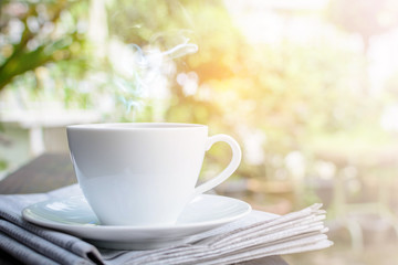 coffee cup clock and news paper on old wooden table nature background