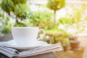 coffee cup clock and news paper on old wooden table nature background