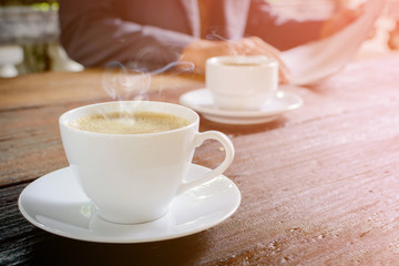 coffee cup clock and news paper on old wooden table nature background