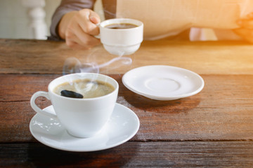 coffee cup clock and news paper on old wooden table nature background