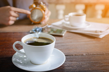 coffee cup clock and news paper on old wooden table nature background