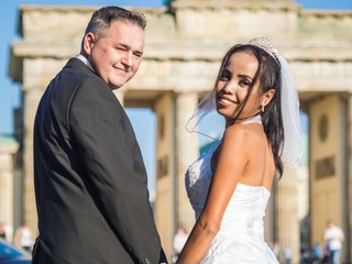 Smiling newlywed couple at Brandenburger Gate in Berlin