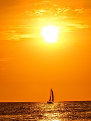 Obraz na płótnie Canvas Sailboat Silhouette in deep orange and yellow sunset Puerto Vallarta Mexico