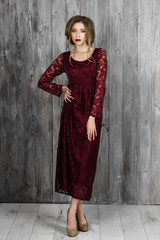 Fototapeta premium Beautiful elegant lady standing in a red long evening dress