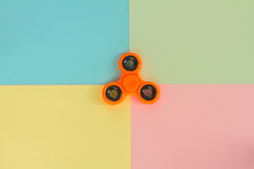 trendy fidget spinners - styled pop art flat lay scene with generic design orange spinner