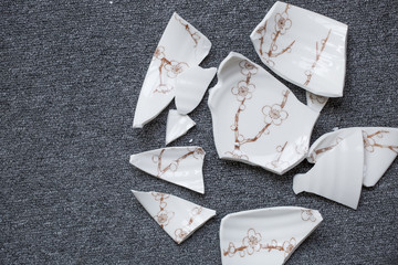 Fototapeta premium Japanese style bowl with plum blossom pattern which has been smashed and broken into lots of pieces on the floor.