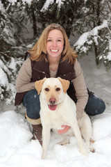 blonde smiling woman in snow with dog