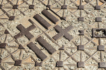 Manhole cover in Barcelona with the flag mark of the city