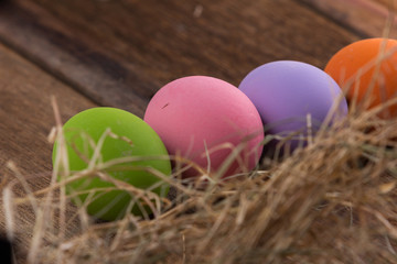 Easter eggs in nest on old wooden background