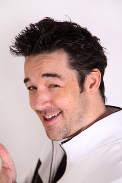 Young attractive man makes a slick, cocky face
