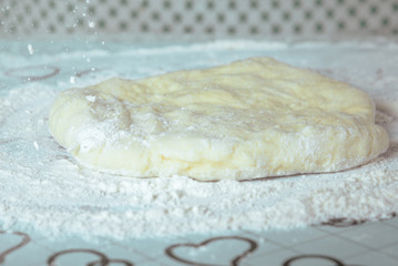 The rolled out dough sprinkled with flour on table