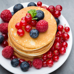 Stack of pancakes with blueberry and fresh berry.