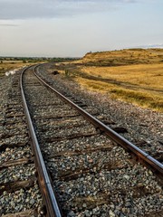 Train tracks disappearing into a rural autumn landscape.