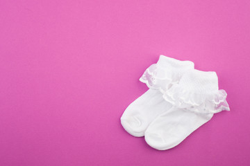 Infant girl socks On a purple background. Baby shower, copy space