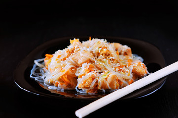Asian traditional food. Fried noodles with chicken meat, vegetable slices.